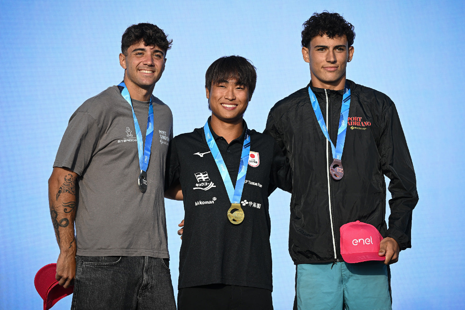 Shuri Araki (centre) wearing his gold medal on the Open Men Long Distance podium