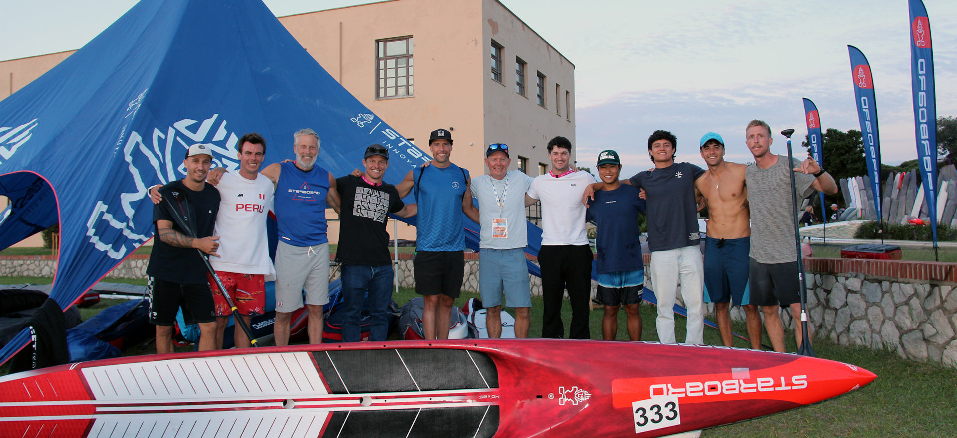 The Starboard Dream Team gathered behind a race board in Sabaudia at the 2026 ICF SUP World Championships